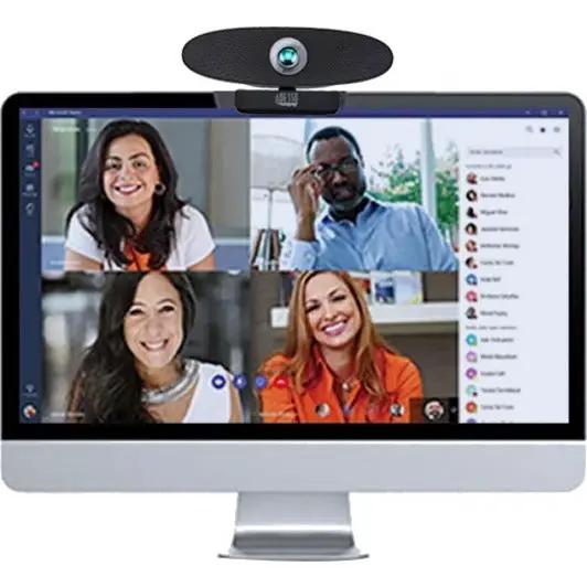 4K Ultra HD Conference Webcam mounted on top of a desktop monitor showing a four-person video conference
