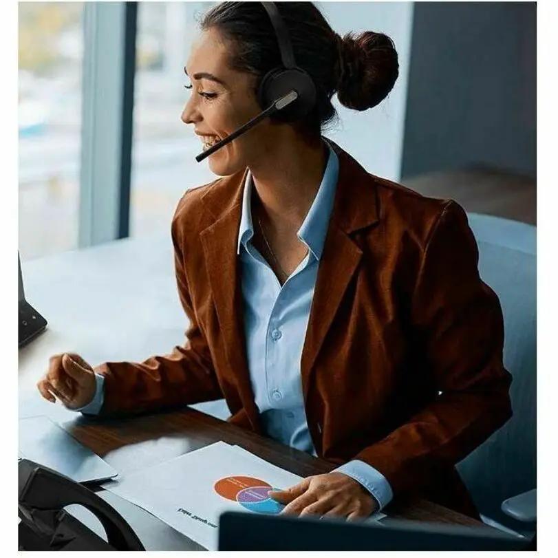 Yealink WH64 Dual UC wireless headset with mic worn by a woman at a desk.