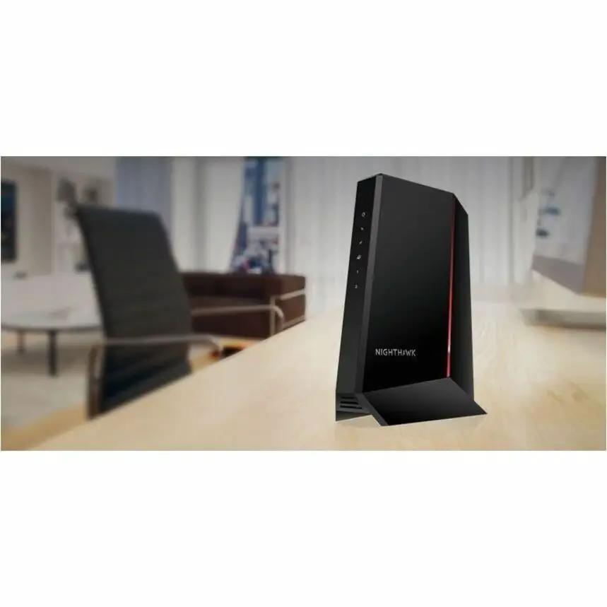 Netgear Nighthawk CM2500 modem gateway, black with a red accent, standing on a desk
