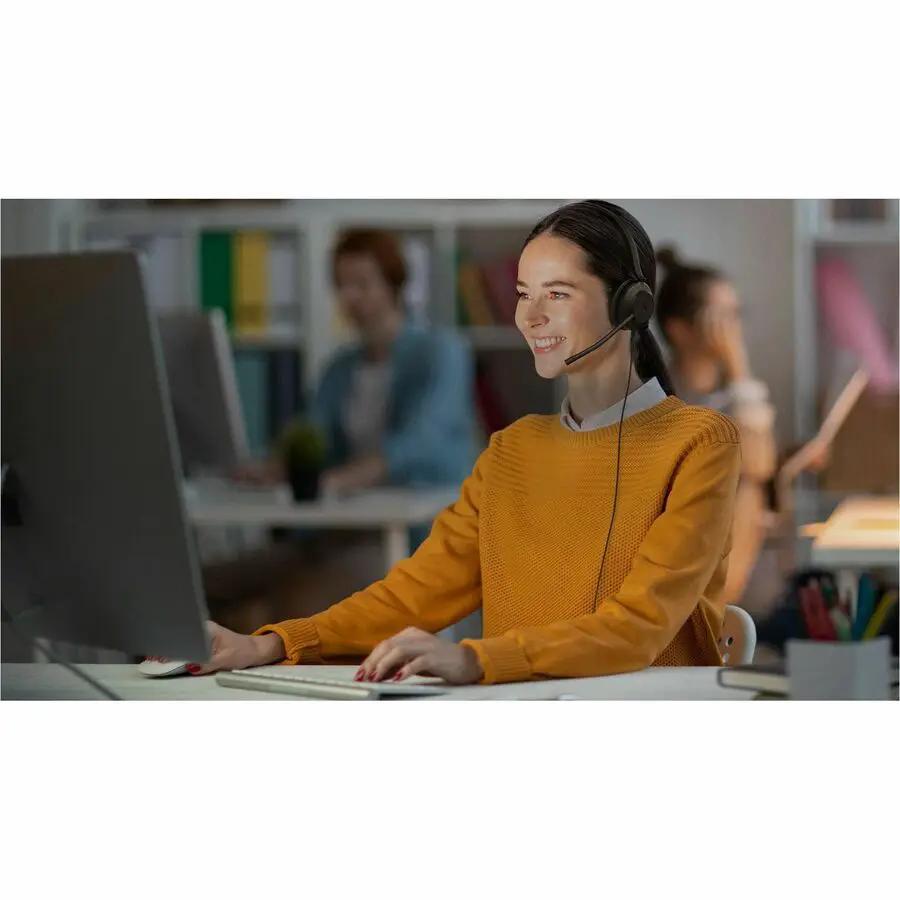 Yealink UH35 Mono UC USB-C headset, black, worn by a woman at a desktop computer.