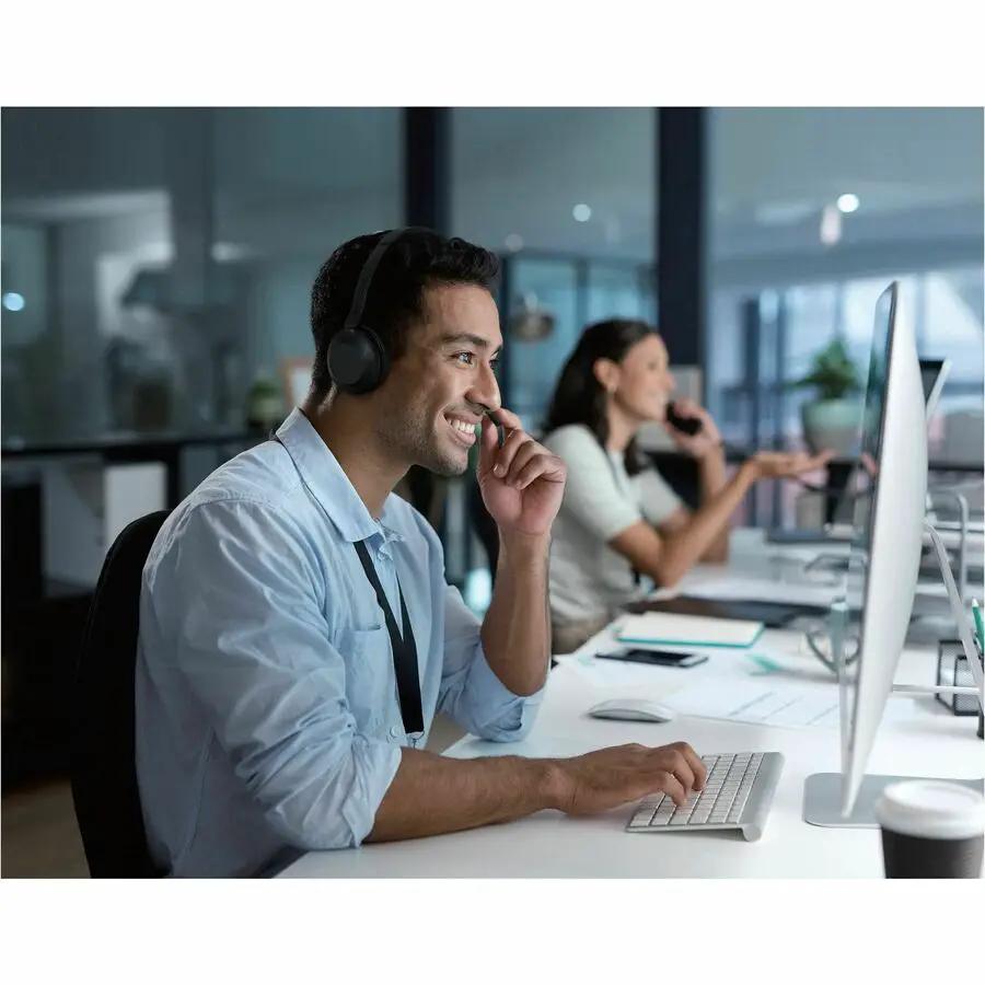 Yealink UH35 Dual UC USB-C headset, black, on an office desk with a computer monitor.