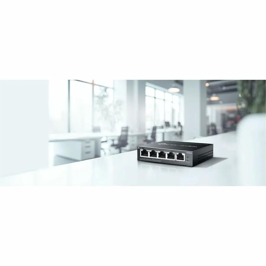 TP-Link Omada 5-Port Gigabit PoE+ Managed Switch black on a white desk in an office.