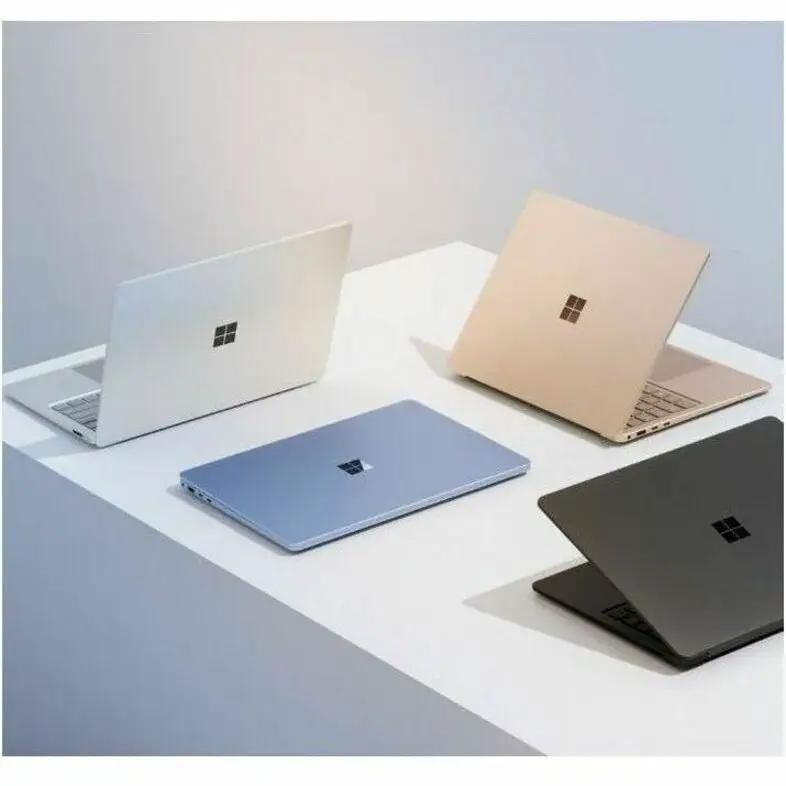 Microsoft Surface Laptop 7 laptops (set of 4) in silver, blue, gold, and black on a white desk