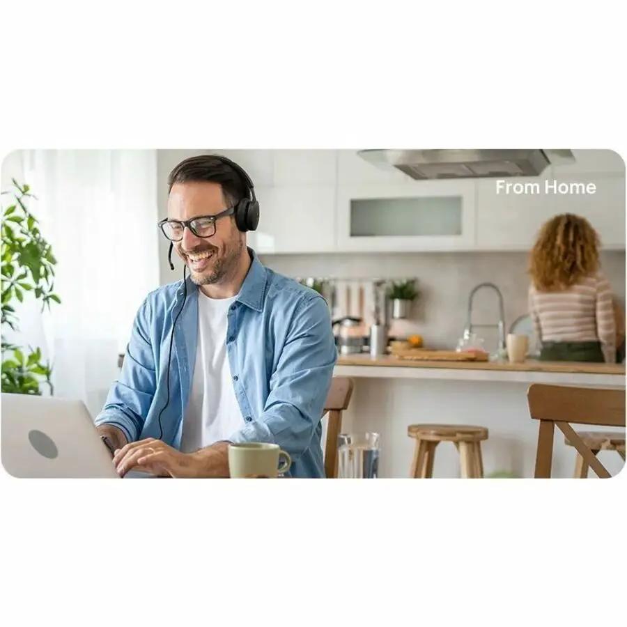 Yealink UH48 Dual MS USB-C/A headset, black over-ear with boom mic, worn by man in a home kitchen.