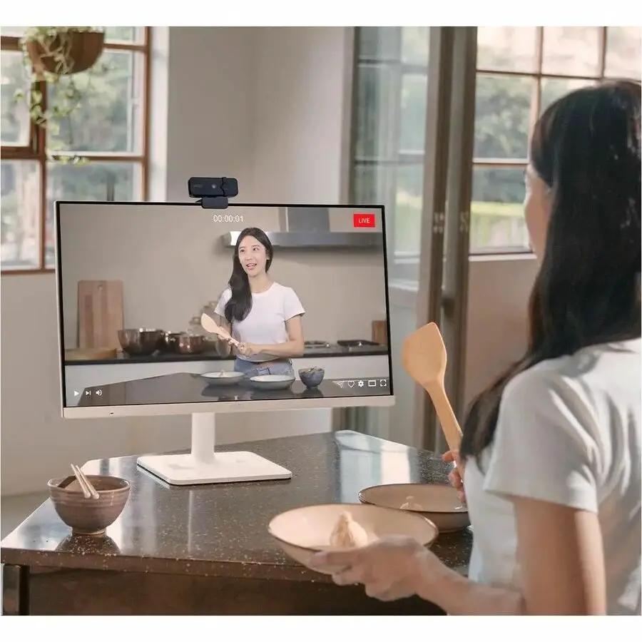 MSI Modern MD272UPSW 27-inch UHD monitor on white stand with top webcam, displaying a cooking livestream.