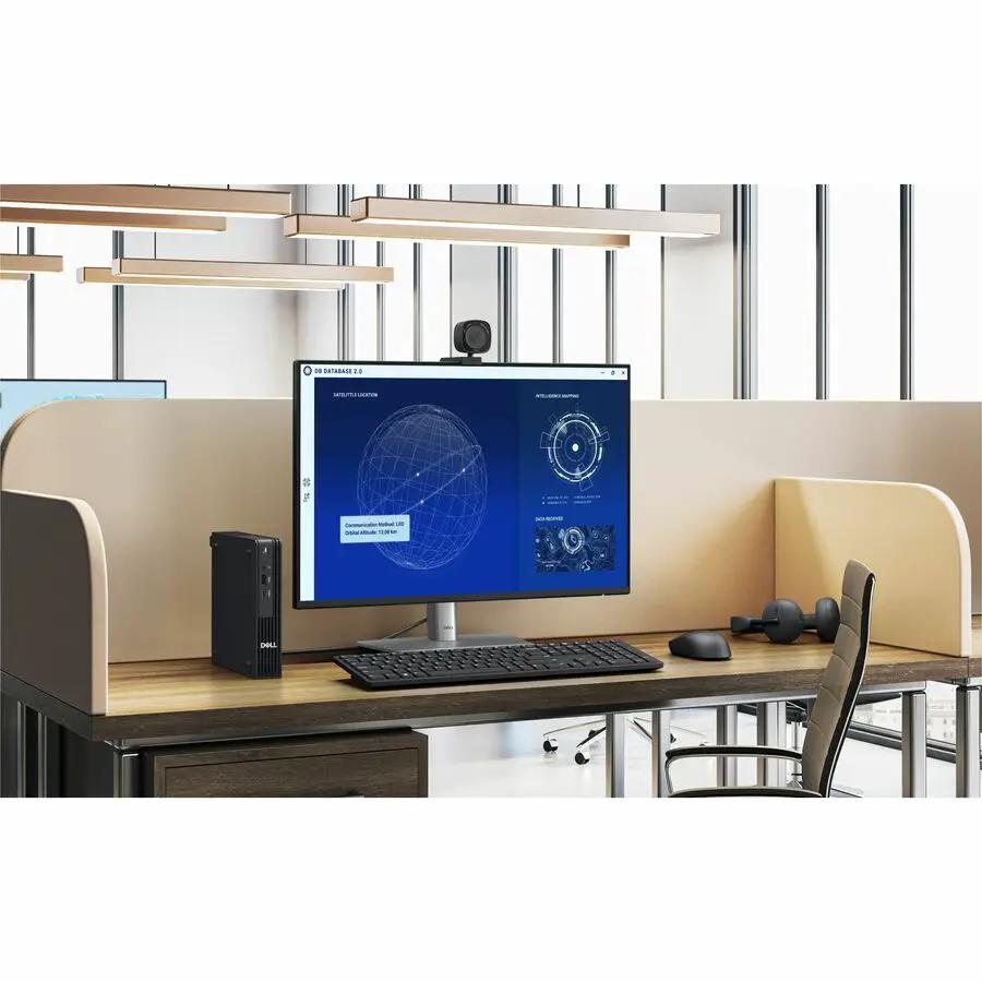Dell QCM1250 Mini PC on a desk beside monitor, keyboard, and mouse in an office cubicle.