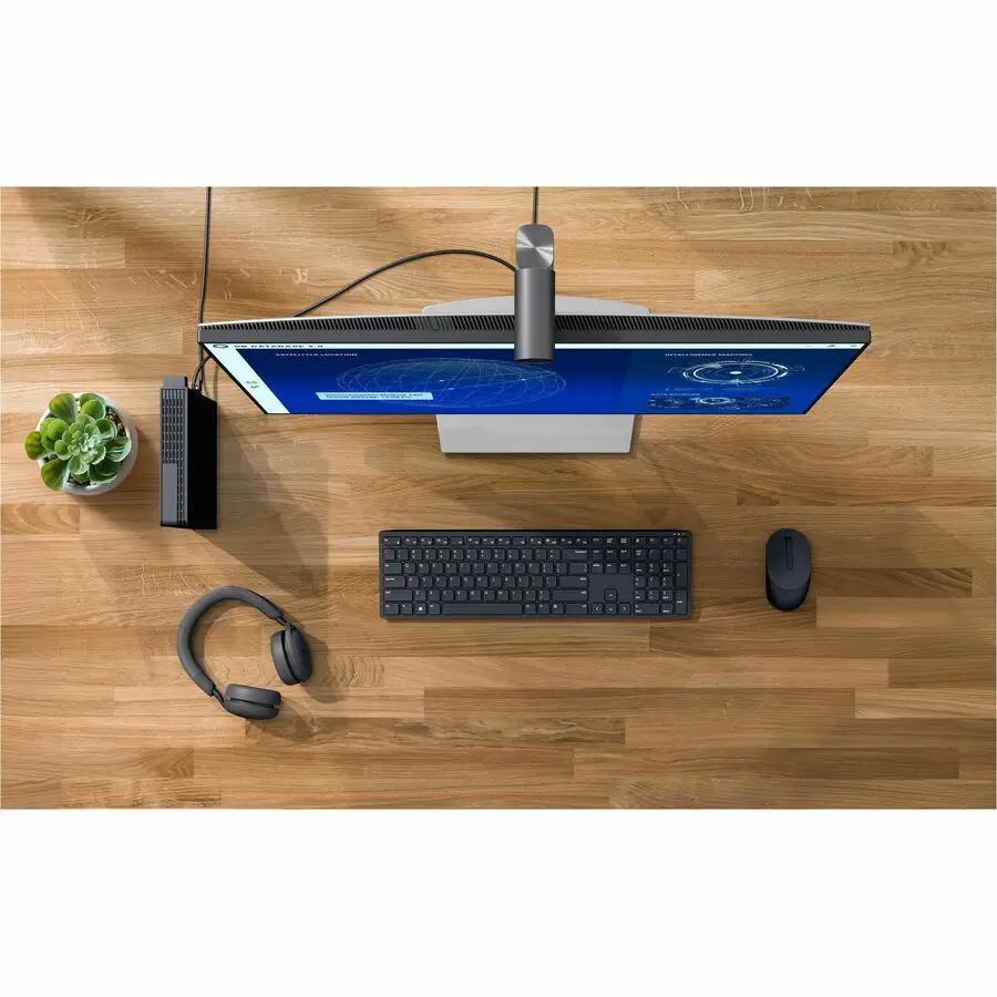 Dell Pro Micro Plus QBM1250 desktop computer, black, on a wooden desk with monitor, keyboard, mouse, and headset