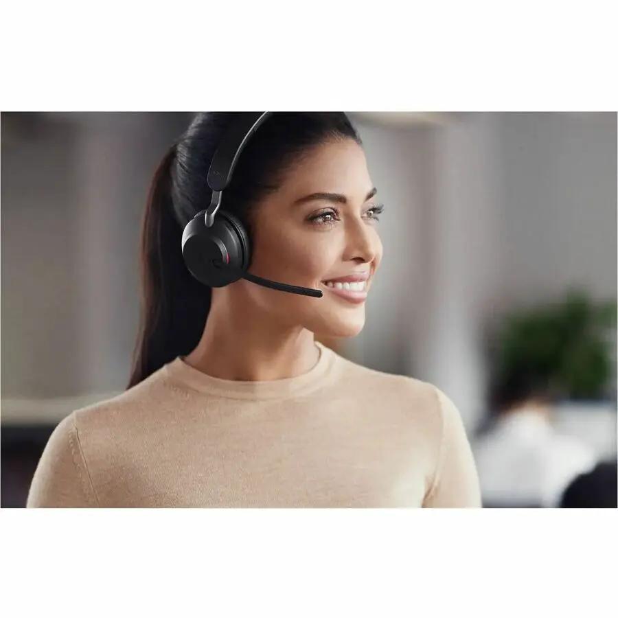 Jabra Evolve2 30 SE headset, black over-ear with boom mic, worn by a woman in an office.