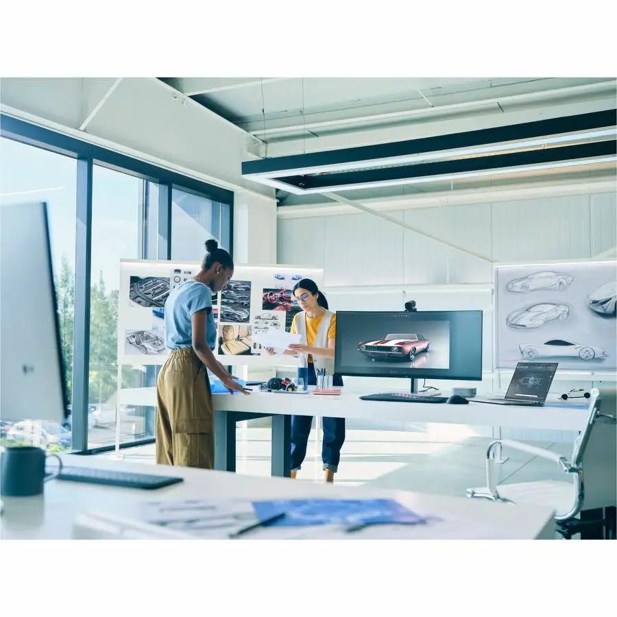 HP ZBook 16 laptop in a bright open-plan office with two people reviewing designs.