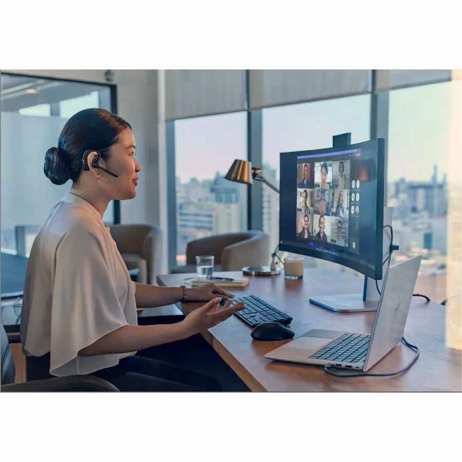 HP EliteBook notebook in silver on a desk with an external monitor displaying a video conference.