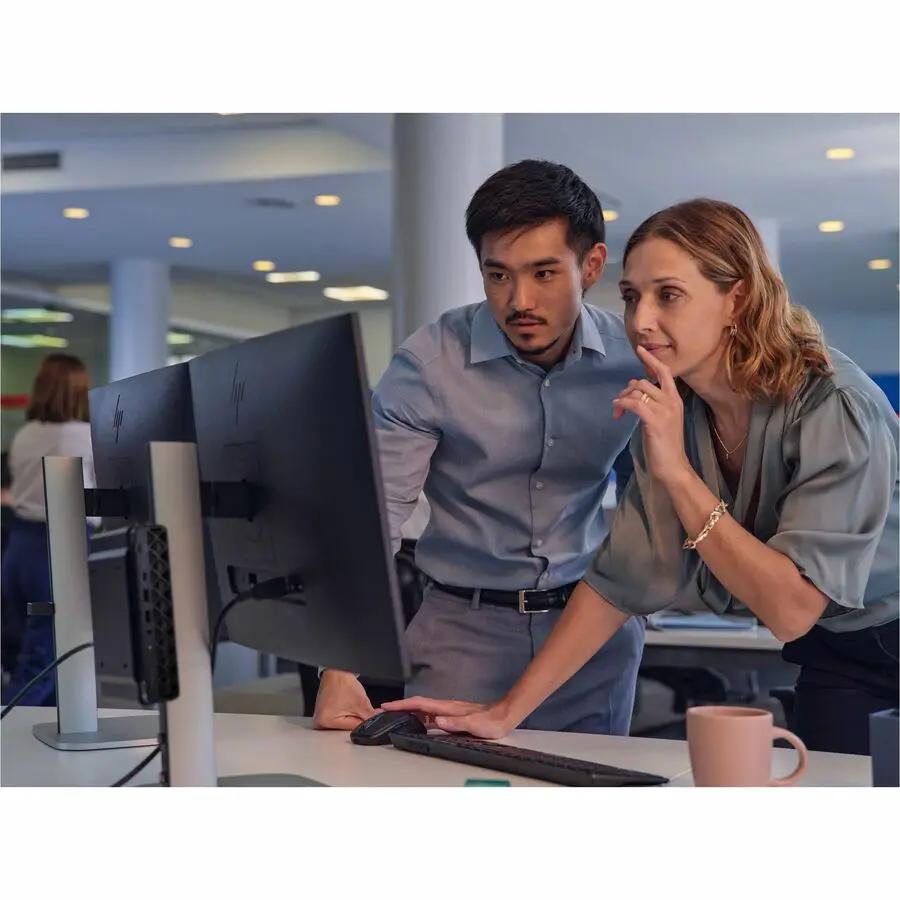 HP EliteDesk 8 Mini G1i PC on a desk with monitor and keyboard; two coworkers viewing the screen.