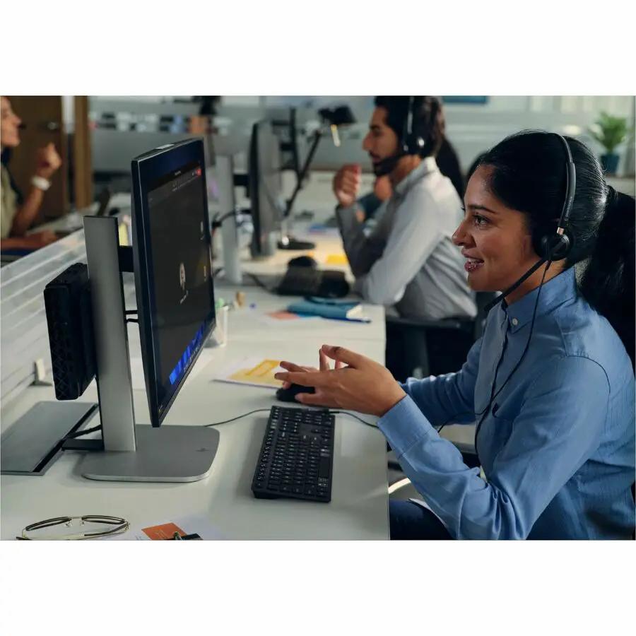HP ProDesk 4 Mini G1i desktop PC (black) on an office desk beside a monitor and keyboard in a call-center workspace.