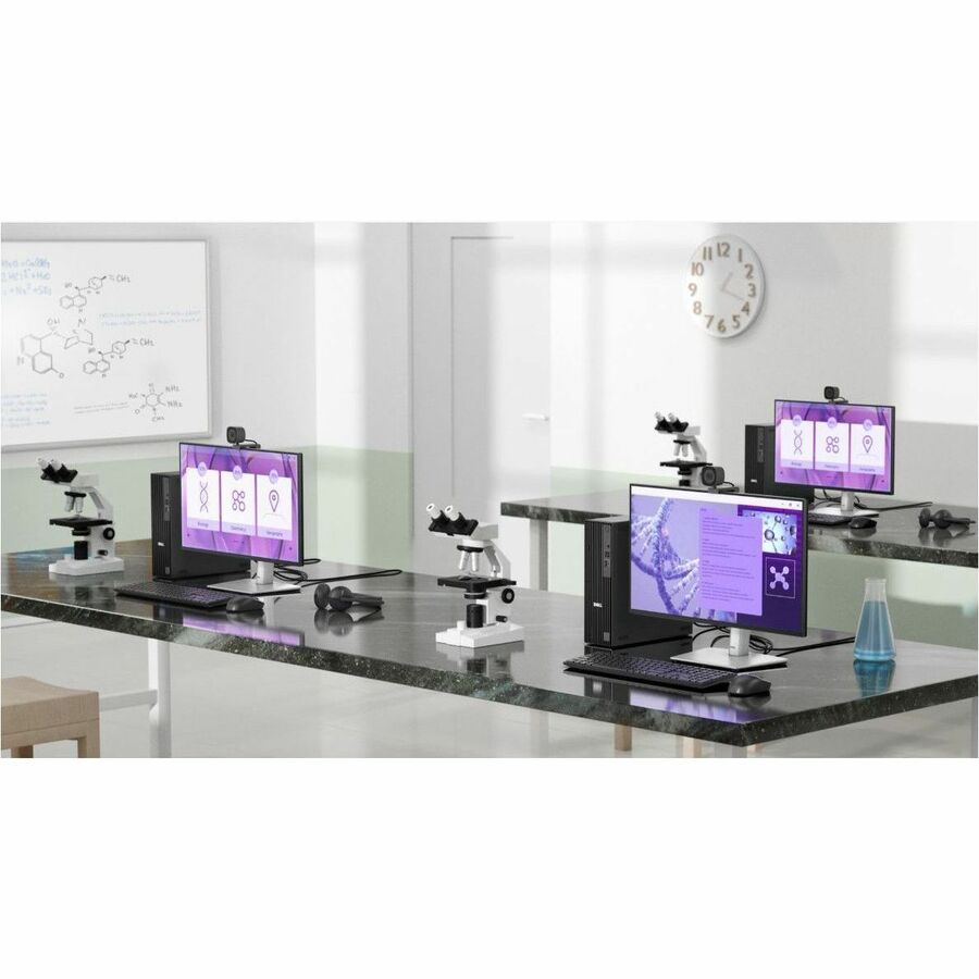 Modern laboratory setup with multiple computer monitors and microscopes on a desk.