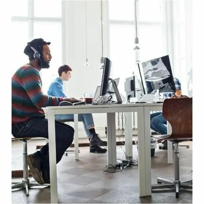 Netgear GS308 8-Port Gigabit Unmanaged Switch in a modern office with coworkers at desks