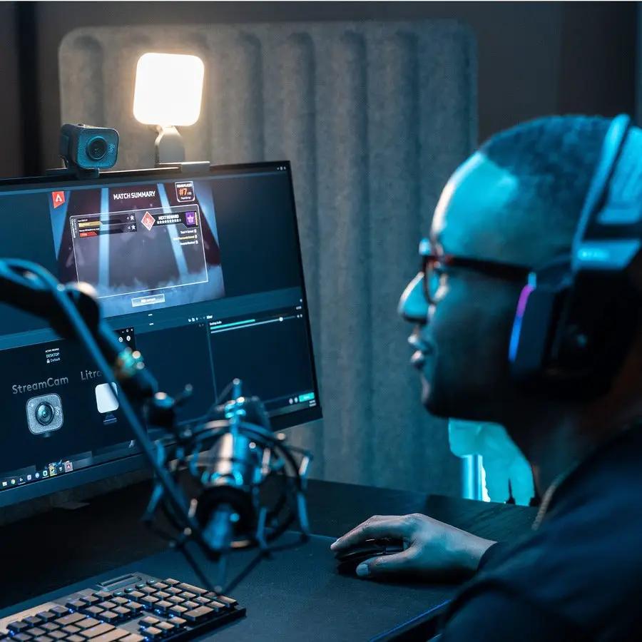 Logitech Stream Cam Plus Graphite webcam mounted on monitor in a streaming setup.