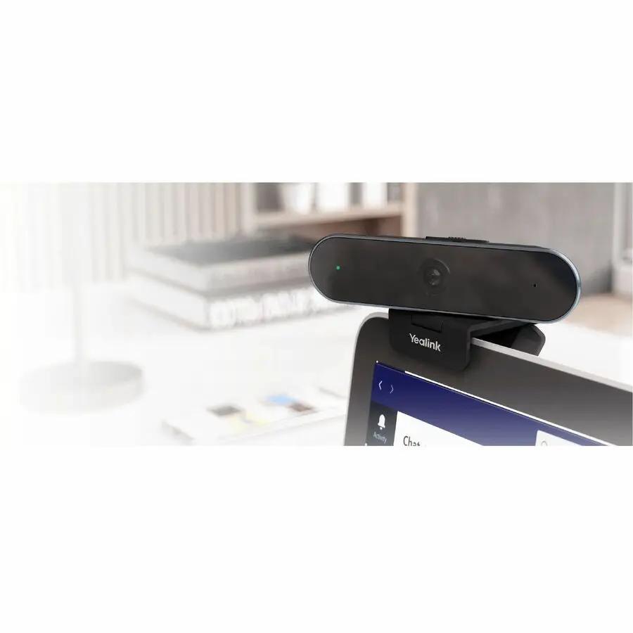Yealink UVC20 USB webcam mounted on a computer monitor; black with green LED indicator.