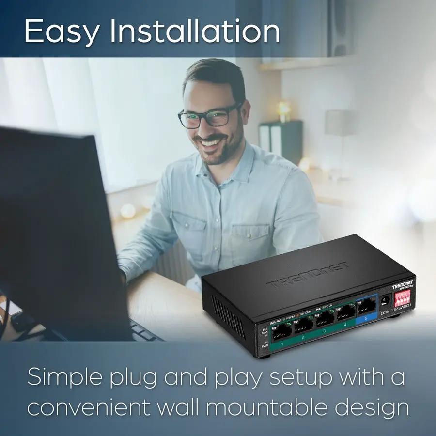 TRENDnet TPE-TG51g 5-Port Gigabit PoE Switch, black, on desk next to laptop