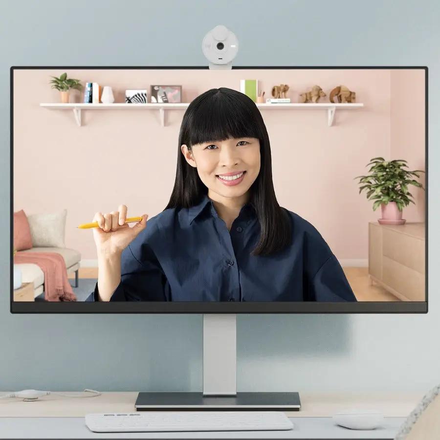 Logitech BRIO webcam, off-white, USB-C, mounted on a monitor at a desk.
