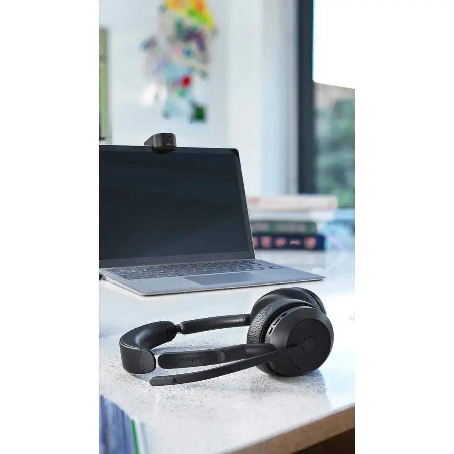 Jabra Evolve2 55 black headset on desk beside laptop