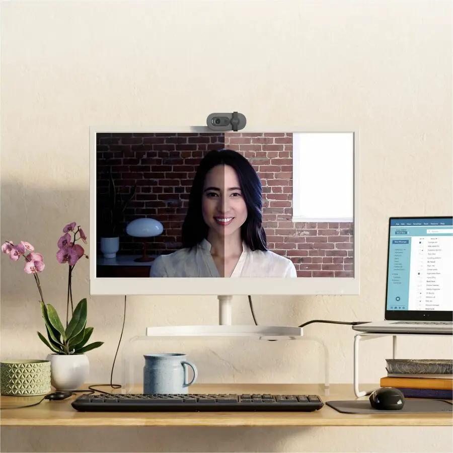 Logitech BRIO 100 webcam, graphite color, USB Type-A, mounted on monitor.