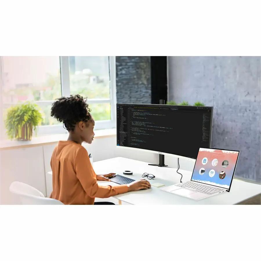 MSI Modern MD342CQPW 34-inch UW-QHD curved monitor on a desk with a laptop