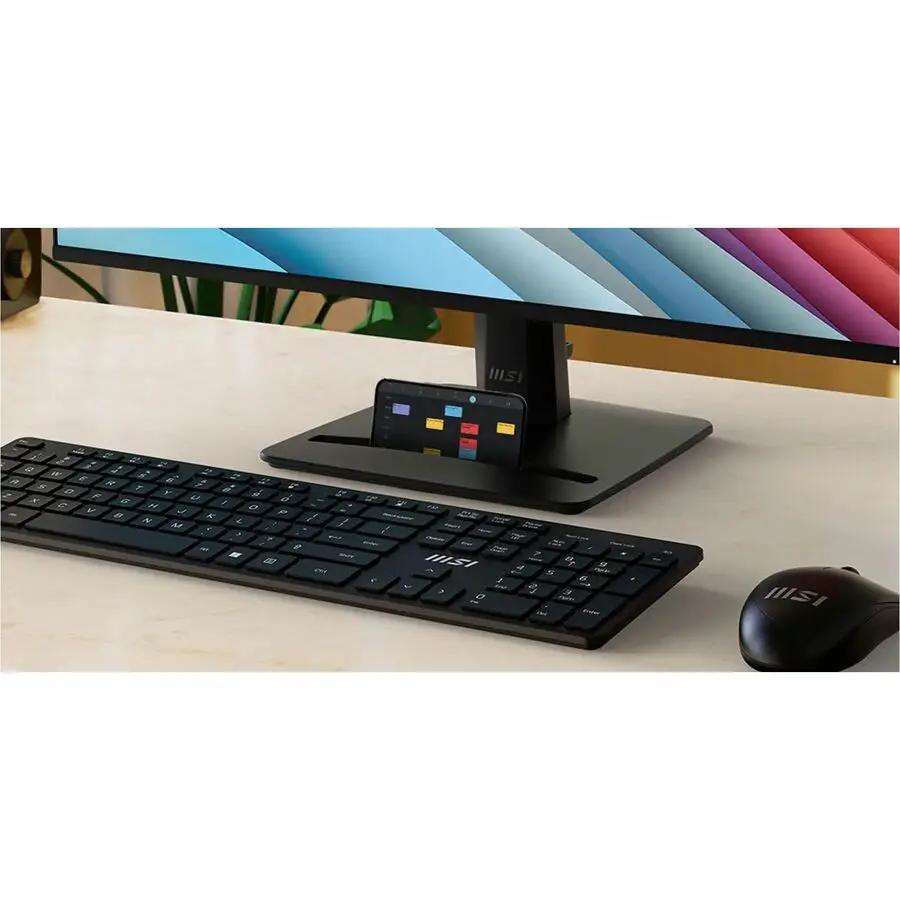 MSI Pro MP275 E2 27-inch Full HD LCD monitor on a desk with black keyboard, black mouse, and phone dock