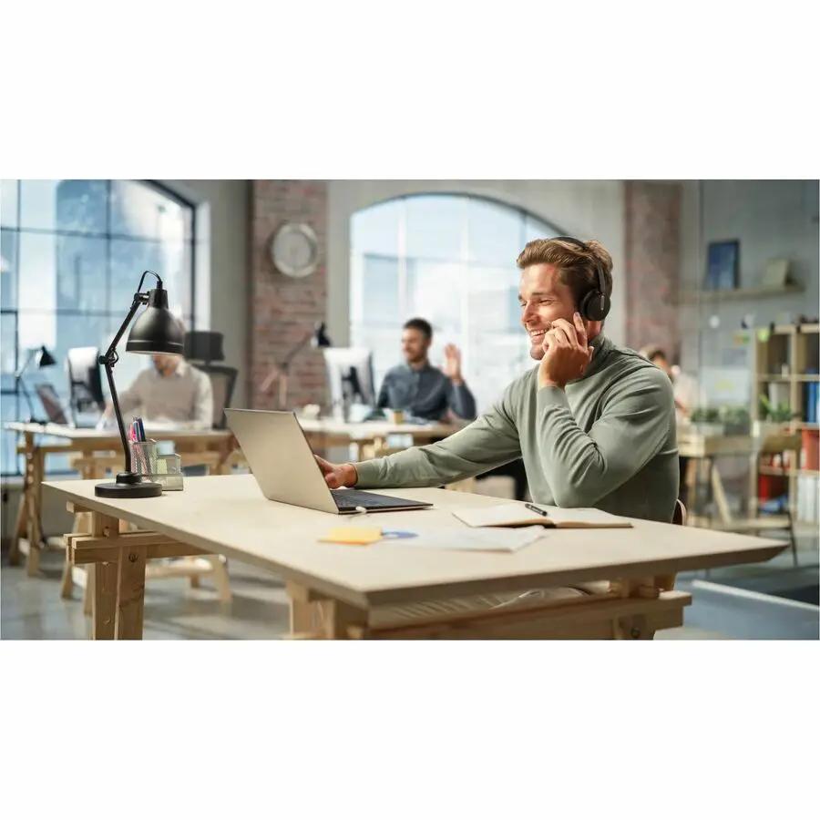 Yealink BH70DLSTMSUSBC/A black wireless headset worn by person at an office desk with a laptop