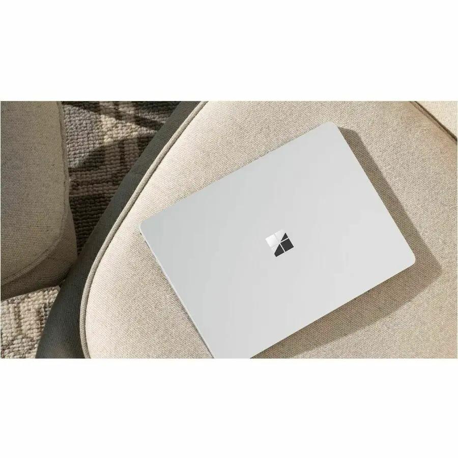 Microsoft Surface Laptop 7 in platinum, closed on a beige couch.