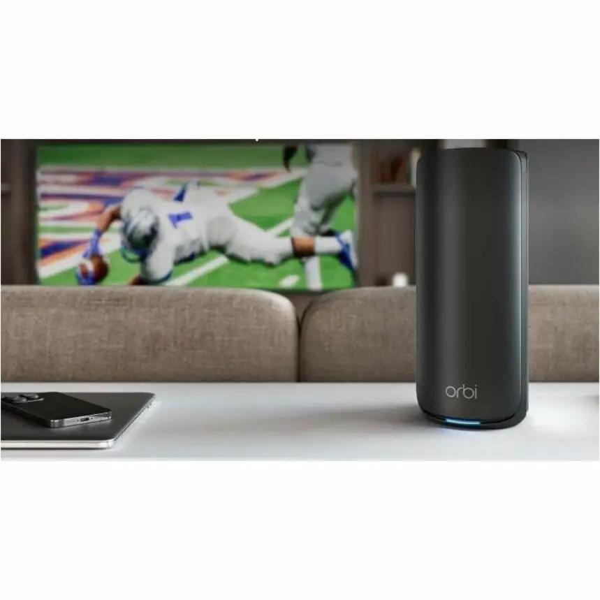 Netgear Orbi ORBI 870 WiFi 7 router, black cylindrical unit on living room table