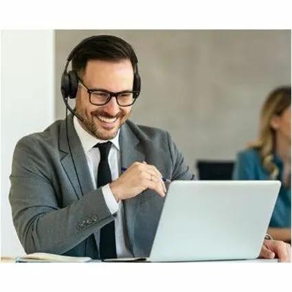 Yealink UH48 Dual MS USB-C/A black headset worn by a person at a desk with a laptop