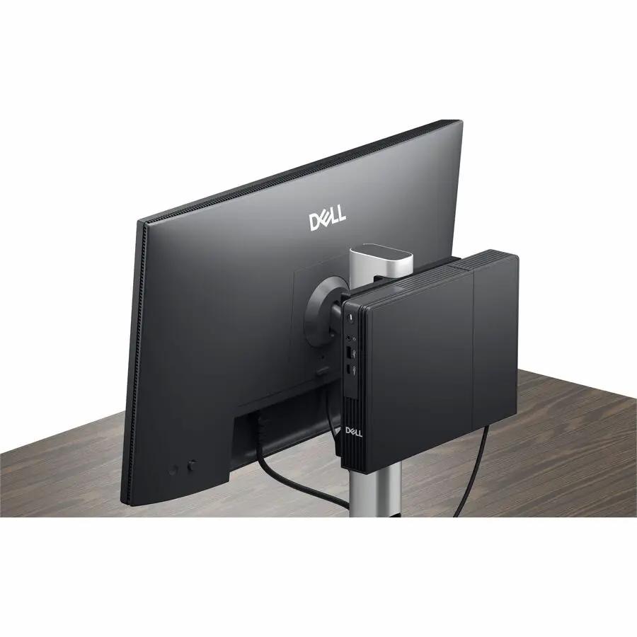 Dell QCM1250 mini PC, black, mounted on a monitor stand.