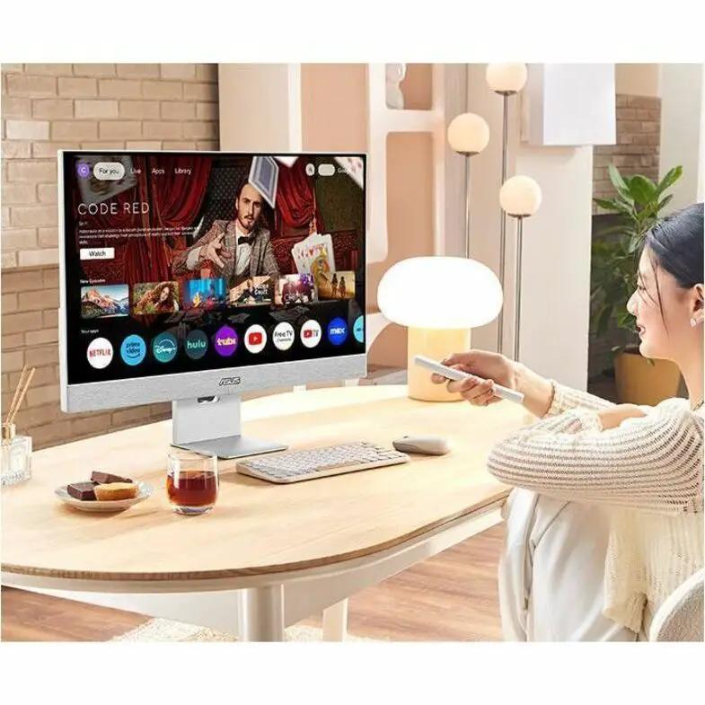 Asus ZenScreen MS32UC 32-inch 4K UHD IPS monitor on a white desk in a home office with a person holding a remote