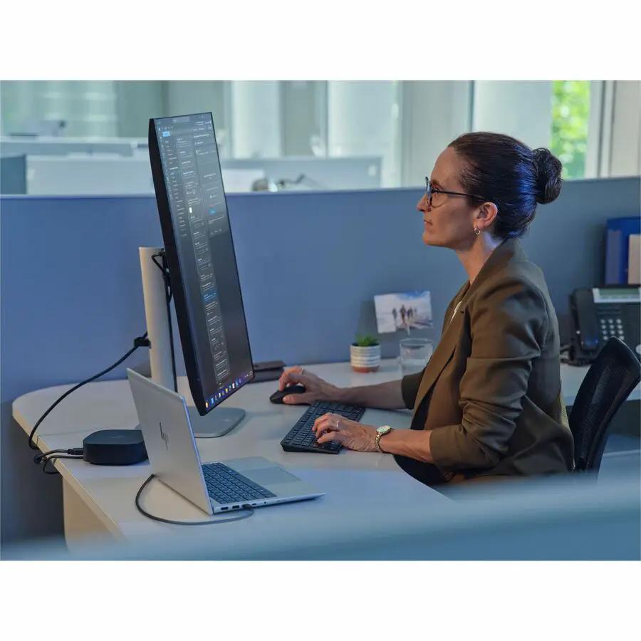 HP EliteBook notebook with a large external monitor on a silver chassis atop a white desk