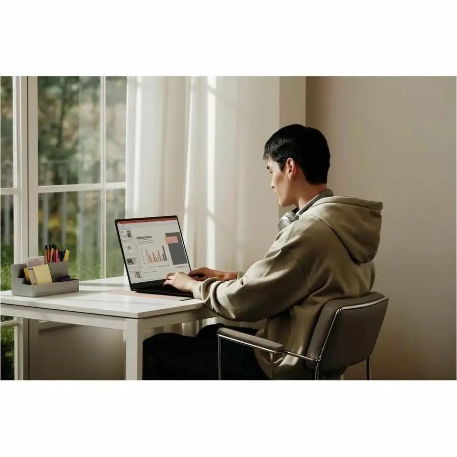 LG Gram 15 laptop by LG Electronics on a white desk, user in a beige hoodie working by a sunlit window