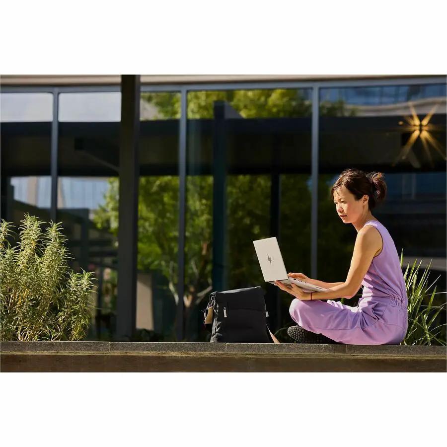 HP EliteBook 14 AI Laptop, silver, being used outdoors.