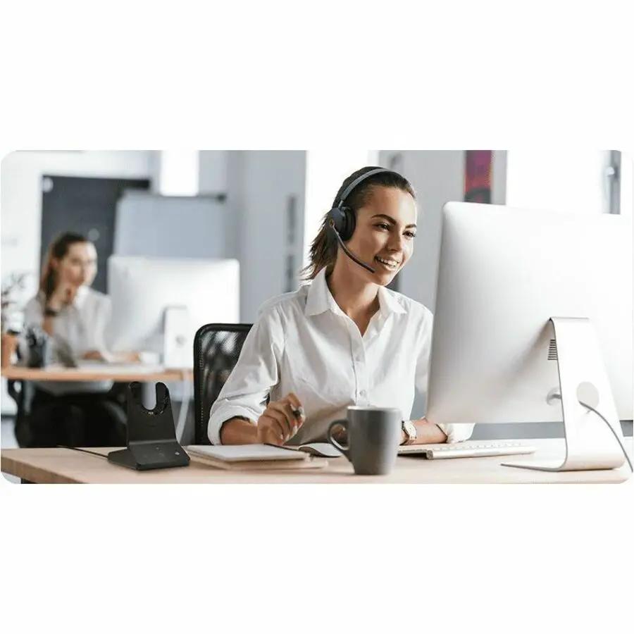 Yealink WH68 UC black wireless headset worn by person at office desk