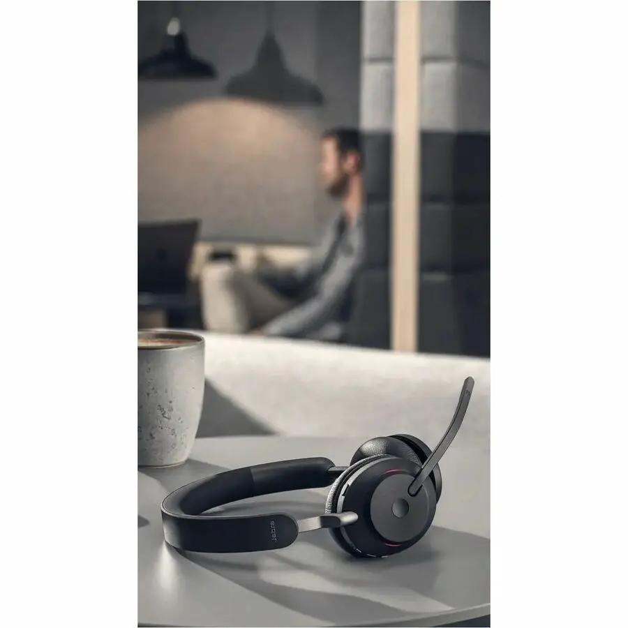 Jabra Evolve2 65 MS Stereo headset, black, on a desk in an office.