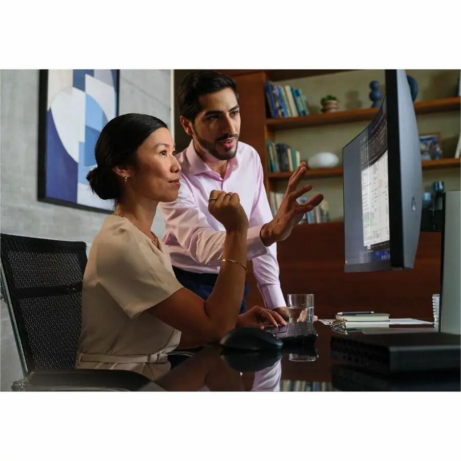 HP EliteDesk 8 G1a mini desktop in black with a large monitor on a glass desk in an office