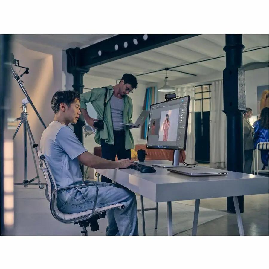 HP 732xk 32-inch 4K UHD monitor on a white desk in a photo studio, with a webcam mounted on top.