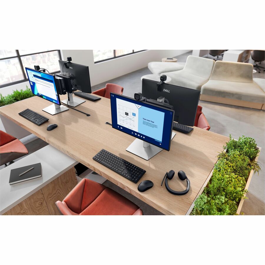Modern office setup with multiple computer monitors on a long desk.