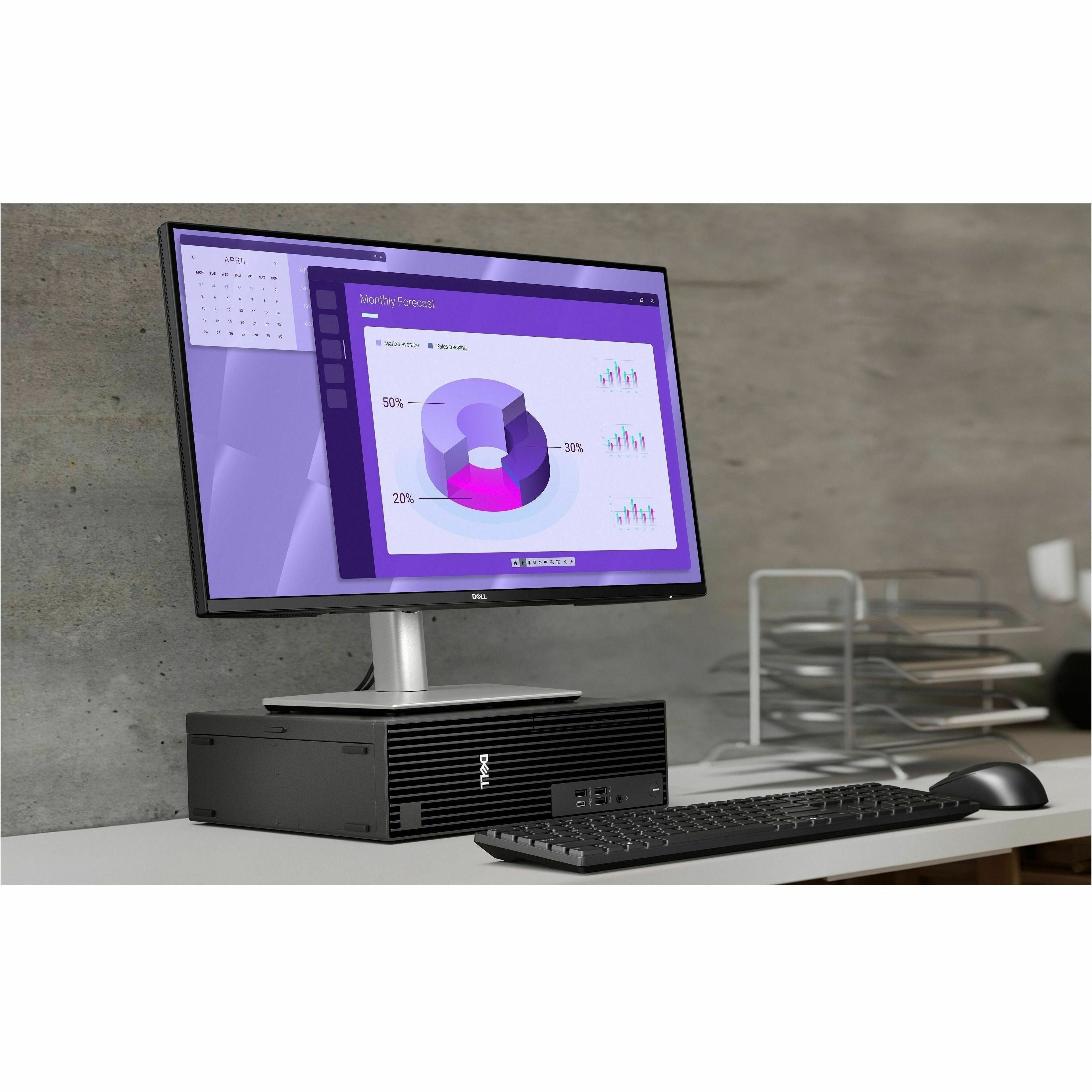 Computer setup with monitor, keyboard, and mouse on a desk against a concrete wall.